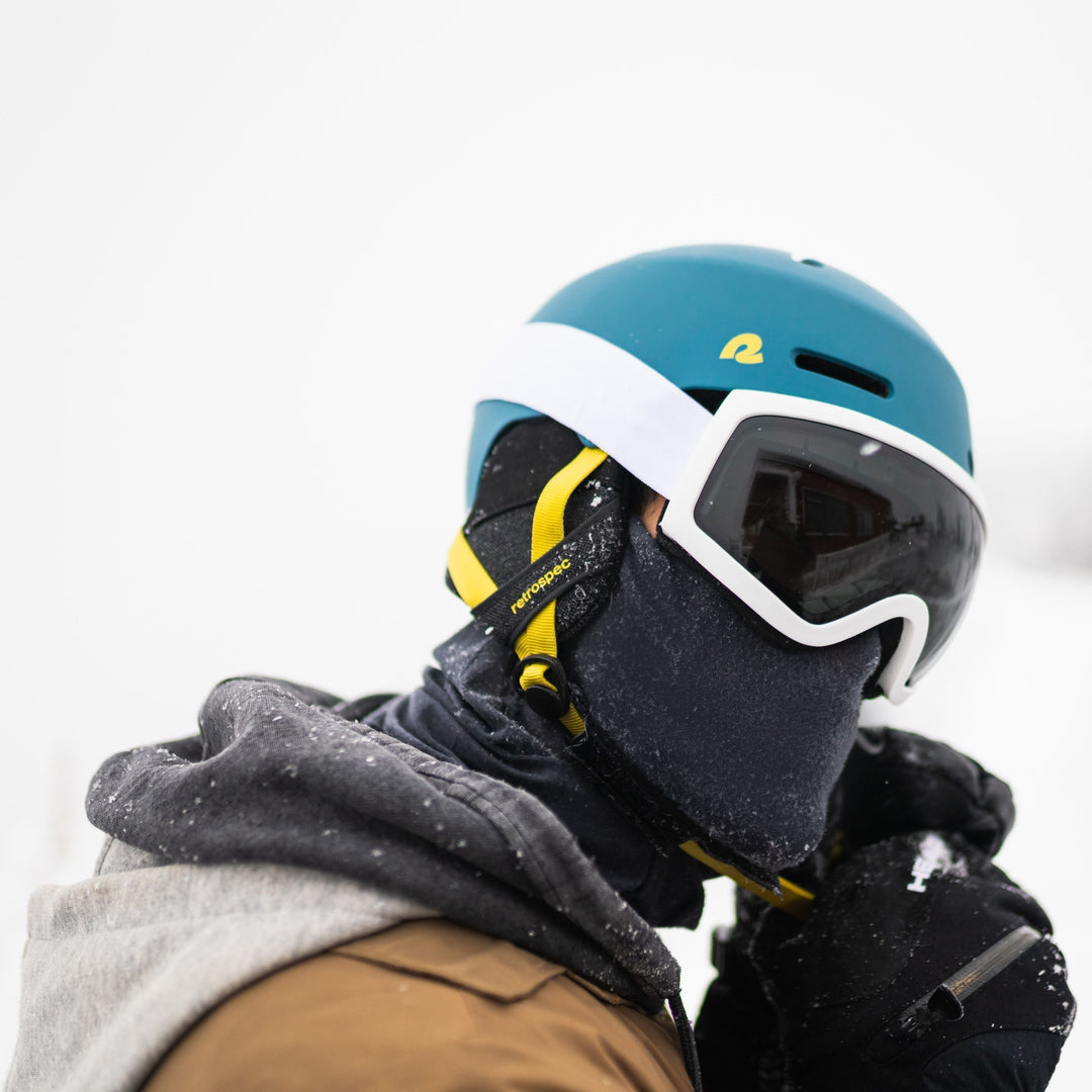 Snowboarder wearing a well-fitted helmet on a snowy mountain slope.
