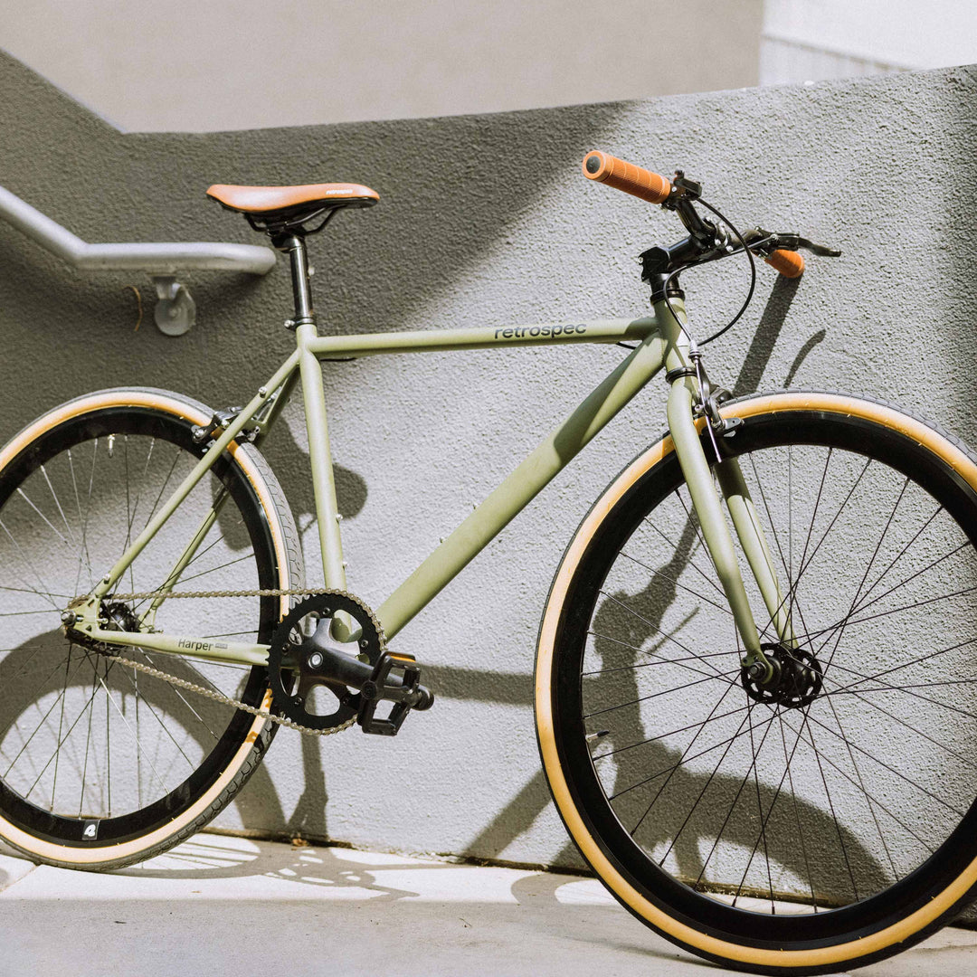 A green bike rests against the wall at the bottom of a stairwell.