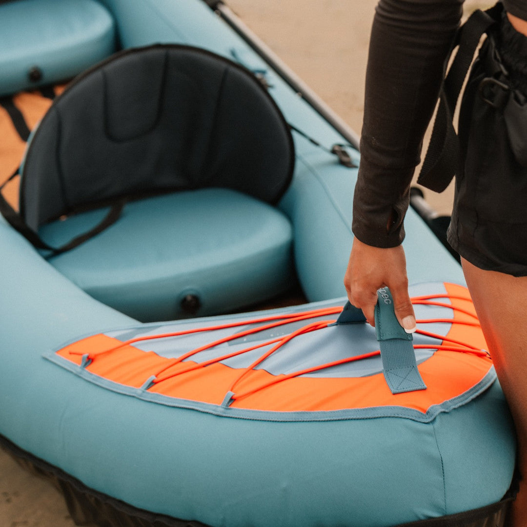Close-up of retrospec Coaster inflatable kayak seat cushion and orange fin with padded back support.