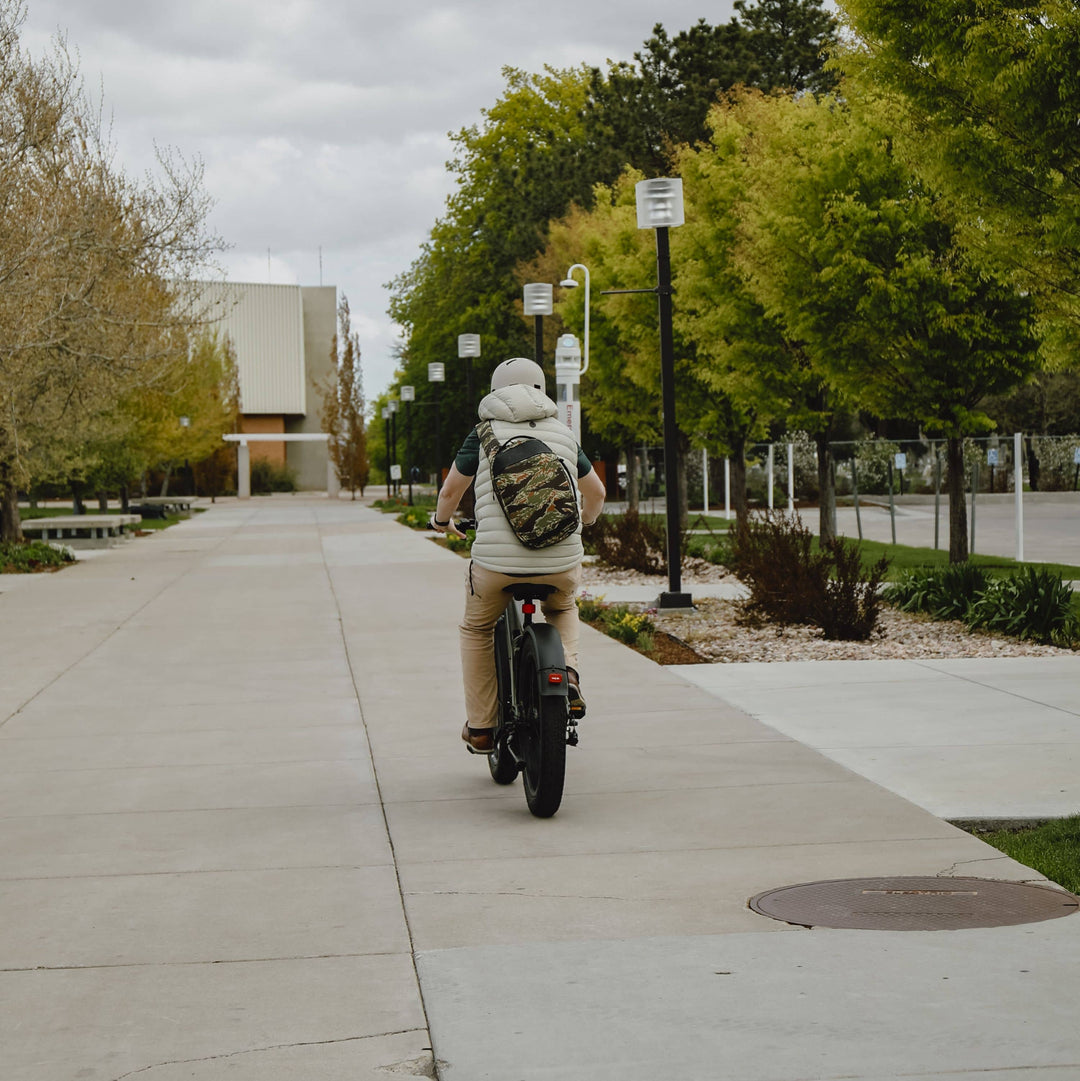 Rider on a Retrospec electric bike enjoying a spring commute through a scenic outdoor setting.