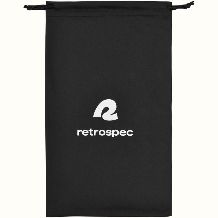 Black drawstring goggle bag with a white retrospec logo and black cord ties, shown flat on a cream background.