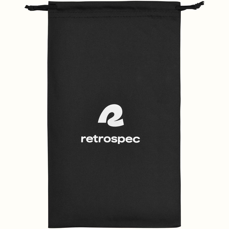 Black drawstring goggle bag with a white retrospec logo and black cord ties, shown flat on a cream background.