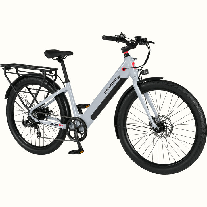 A modern, sleek Abbot Rev 2 Step Through electric bike in gray with a low step-through frame, wide tires, and a rear rack, branded "retrospec."