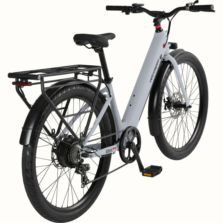 A modern, sleek Abbot Rev 2 Step Through electric bike in gray with a low step-through frame, wide tires, and a rear rack, branded "retrospec."