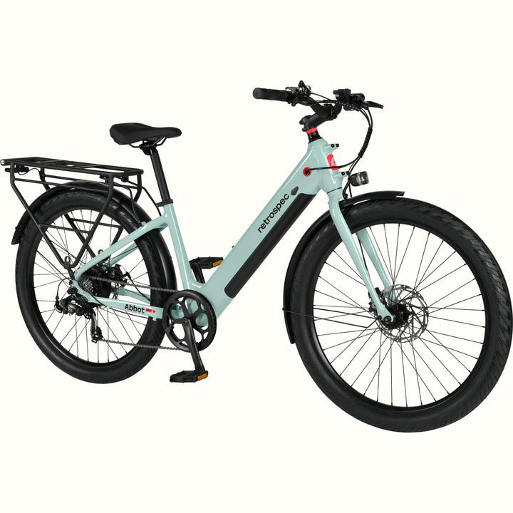 A modern, sleek Abbot Rev 2 Step Through electric bike in light greenish blue with a low step-through frame, wide tires, and a rear rack, branded "retrospec."