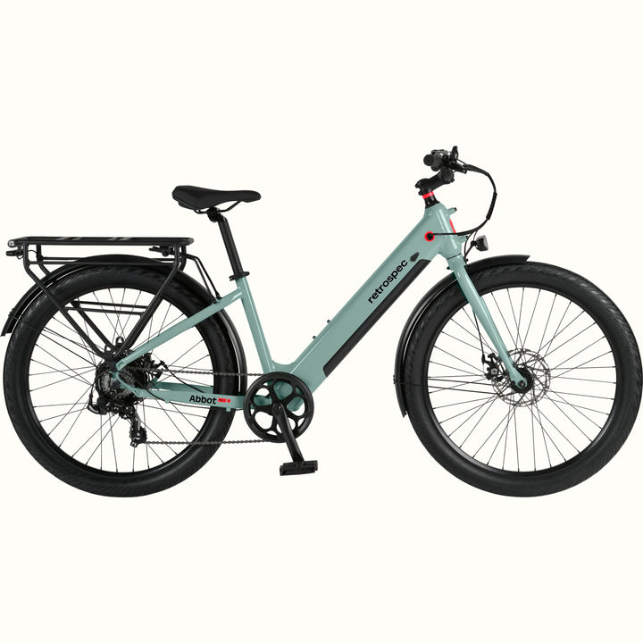 A modern, sleek Abbot Rev 2 Step Through electric bike in light greenish blue with a low step-through frame, wide tires, and a rear rack, branded "retrospec."