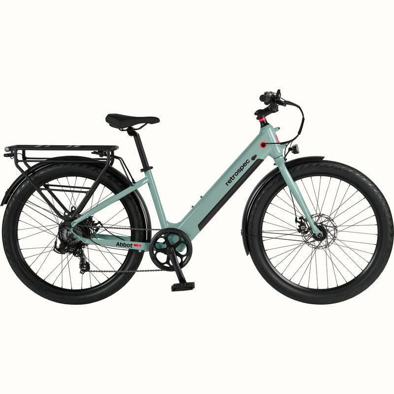 A modern, sleek Abbot Rev 2 Step Through electric bike in light greenish blue with a low step-through frame, wide tires, and a rear rack, branded "retrospec."