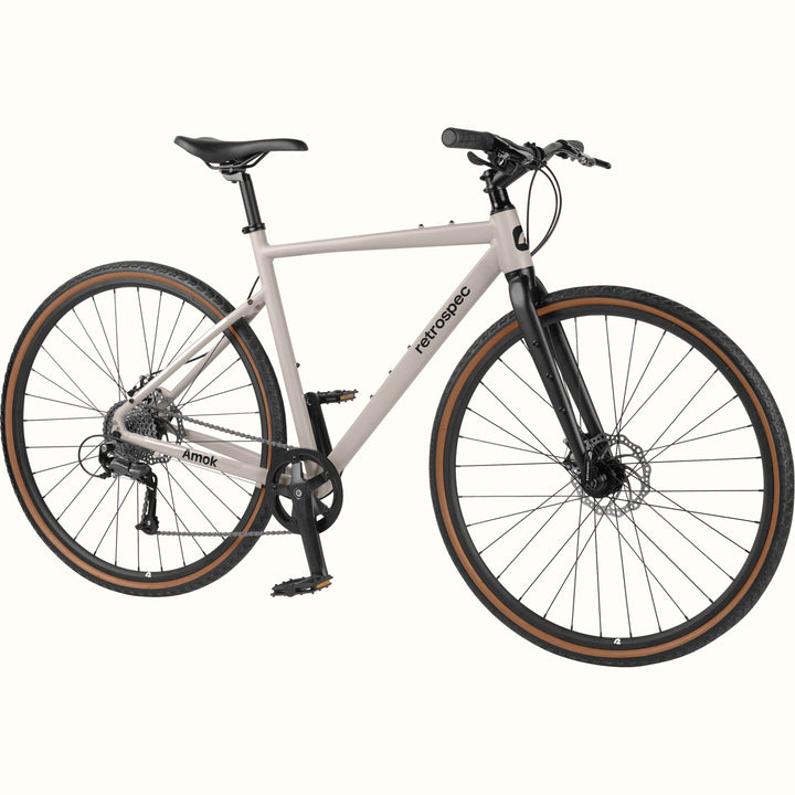 A light gray road bicycle with black components, black tires with brown sidewalls, and a black frame, shown against a plain off-white background.