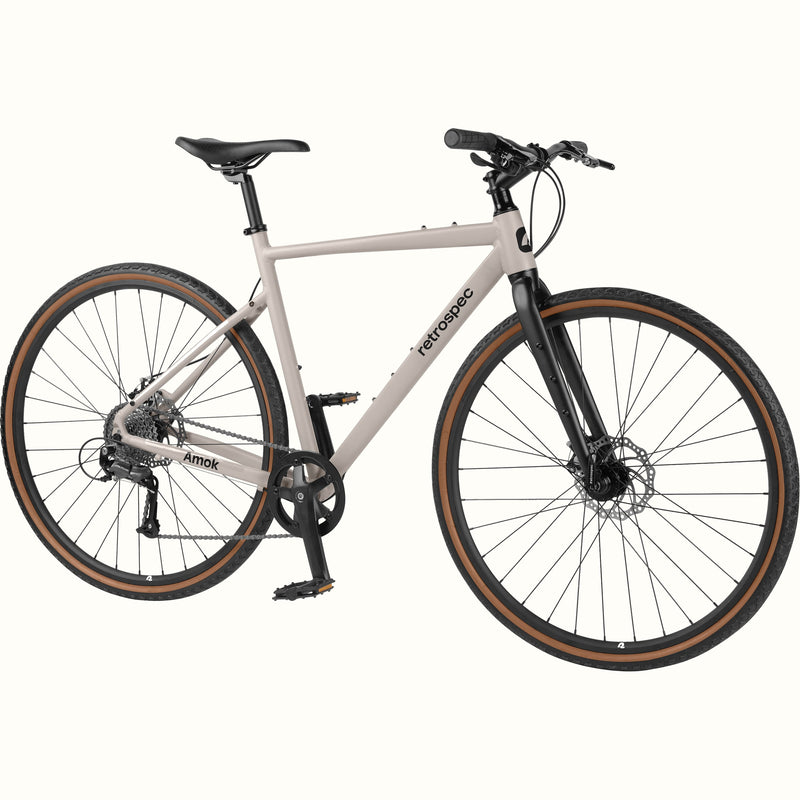A light gray road bicycle with black components, black tires with brown sidewalls, and a black frame, shown against a plain off-white background.