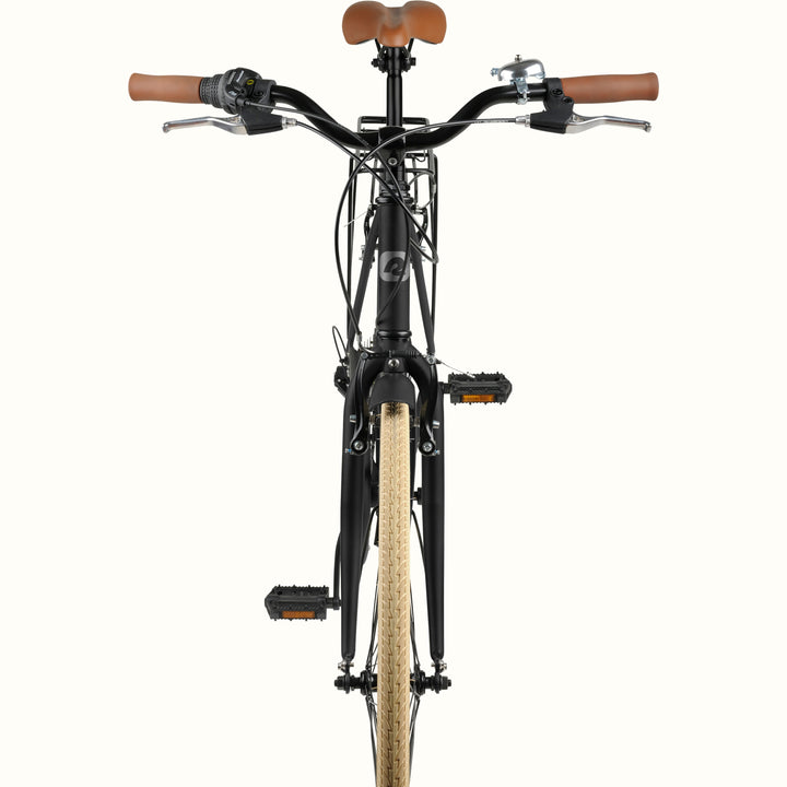Front view of a black bicycle with brown leather saddle and handlebar grips, and a tan sidewall tire, shown against a plain white background.