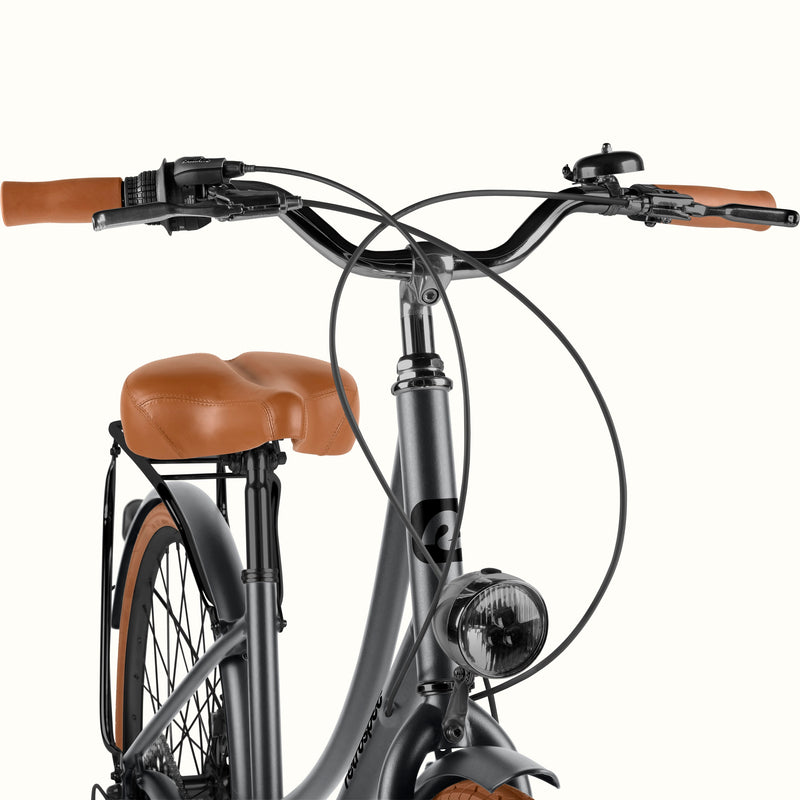 Close-up of the retrospec Beaumont Plus commuter bike cockpit with headlight, bell, brown grips, and brown saddle.