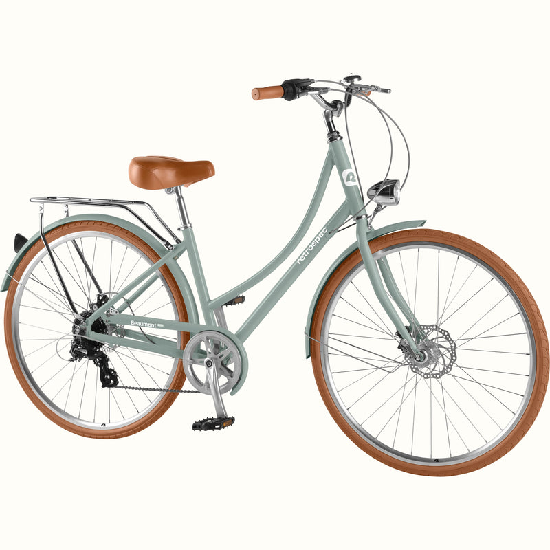 retrospec Beaumont Plus, a cruiser bike for women, in sage haze with rear rack, disc brakes, and 8 speed drivetrain.