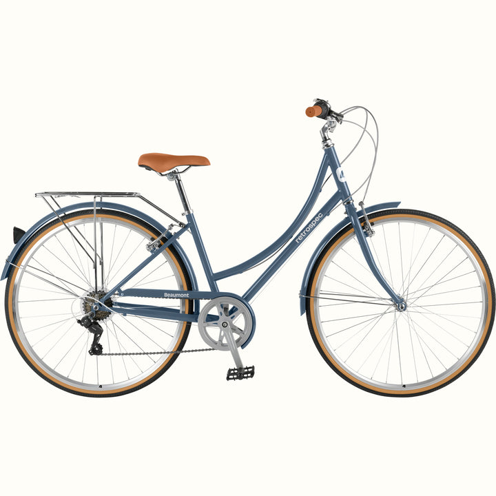 retrospec Beaumont ST commuter bike in dusk blue, 3/4 front view showing rear rack, tan wall tires, and brown grip.