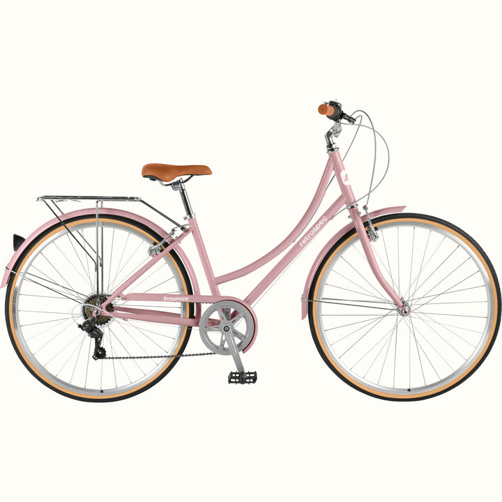 retrospec Beaumont ST step through bike in dusty rose with rear rack, tan wall tires, and brown leather saddle on white background.