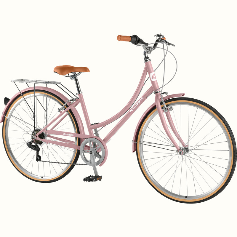 retrospec Beaumont ST commuter bike in dusty rose, 3/4 front view with rear rack, tan wall tires, and brown leather saddle.