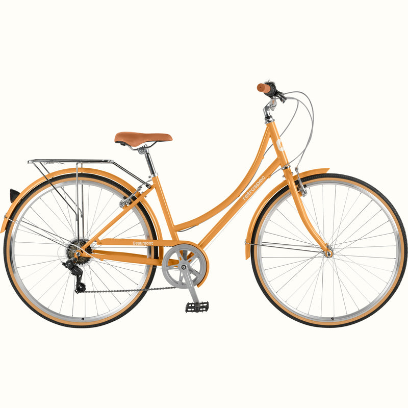 Retrospec Beaumont step through bike in Turmeric with rear cargo rack, brown saddle, swept-back handlebars, and tan-wall tires on a white background.

