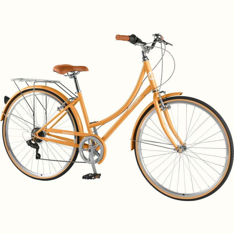 retrospec Beaumont ST urban bike in Turmeric, 3/4 front view showing swept-back handlebars, brown leather grips, rear rack, and tan-wall tires.