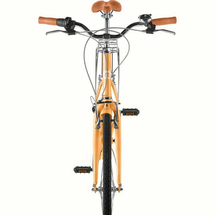 Front view of retrospec Beaumont ST cruiser bike for women showing swept-back handlebars, brown leather grips, bell, and Turmeric front fork.