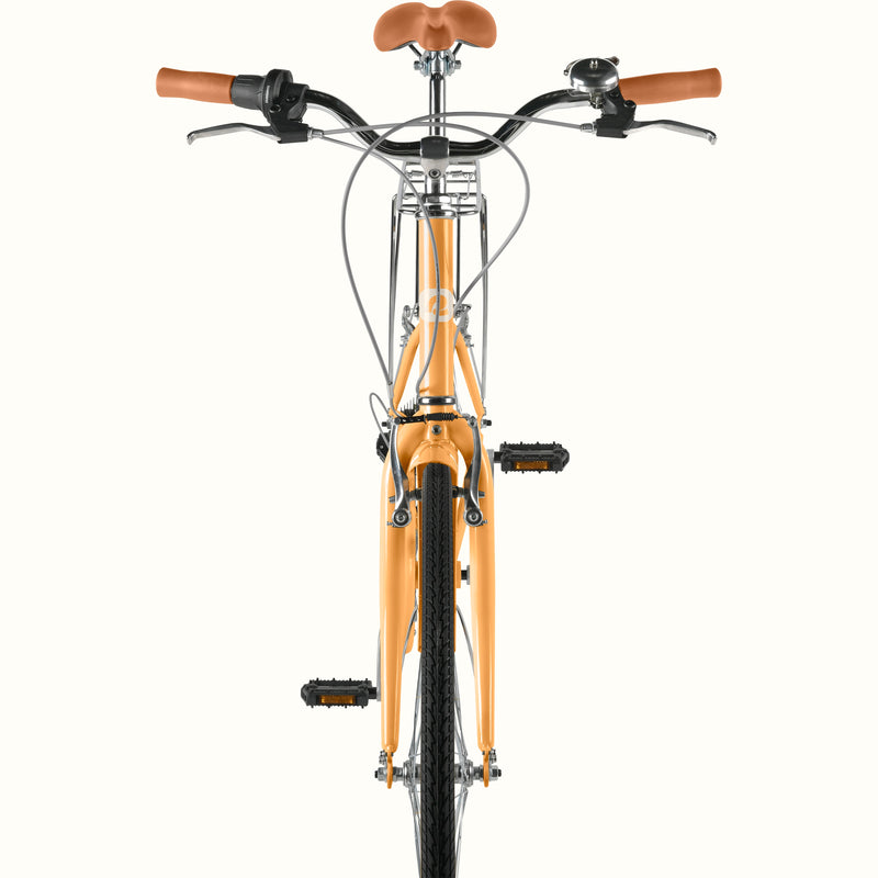Front view of retrospec Beaumont ST cruiser bike for women showing swept-back handlebars, brown leather grips, bell, and Turmeric front fork.