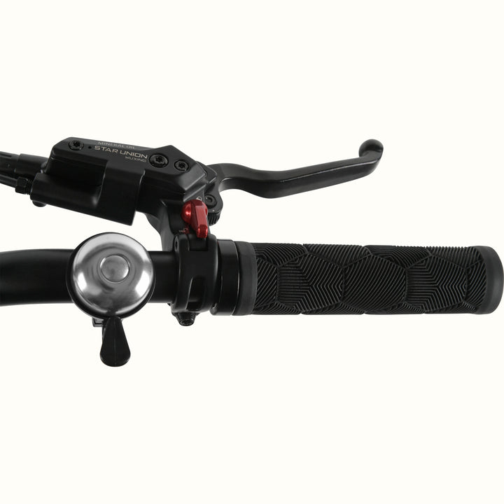 Close-up of the Boca Rev 2 Electric Tricycle's handlebar with brake levers and bell on a white background.
