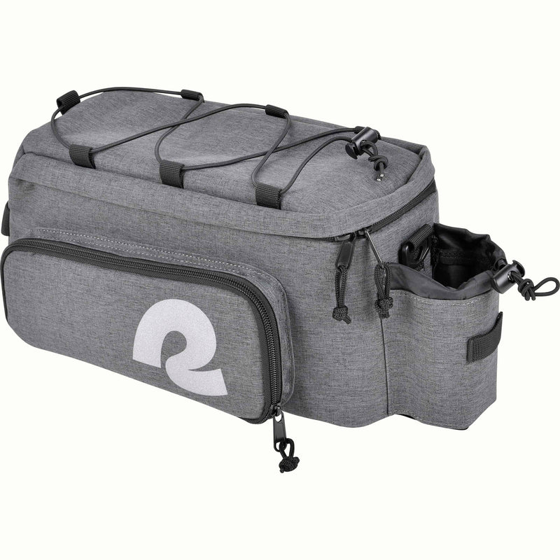 A gray heather bicycle trunk bag with a large white stylized reflective 'R' logo on the front pocket, top black bungee straps, and a side bottle holder, shown on a plain white background.