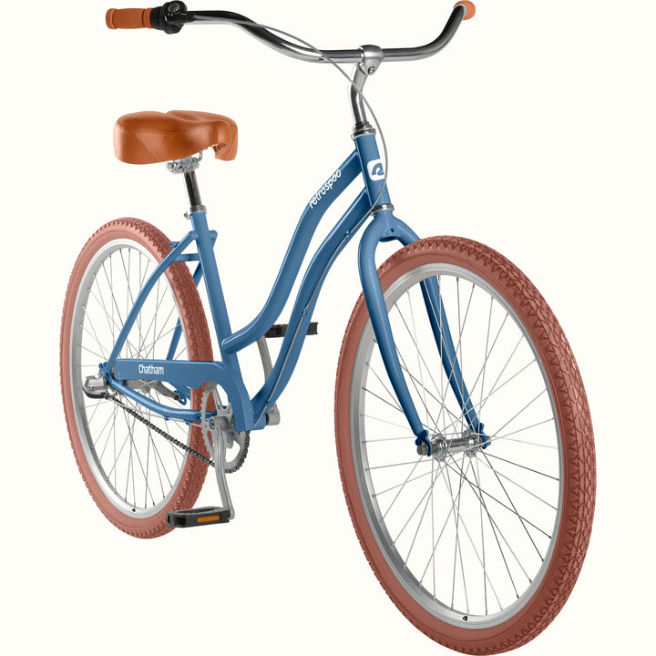 retrospec Chatham women's cruiser bike showing the step-through blue frame, chain, and pedals from a 3/4 angle.