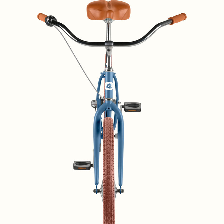 Front view of the retrospec Chatham 3 speed step through cruiser bicycle handlebar, headtube logo, and blue fork with brown tire.