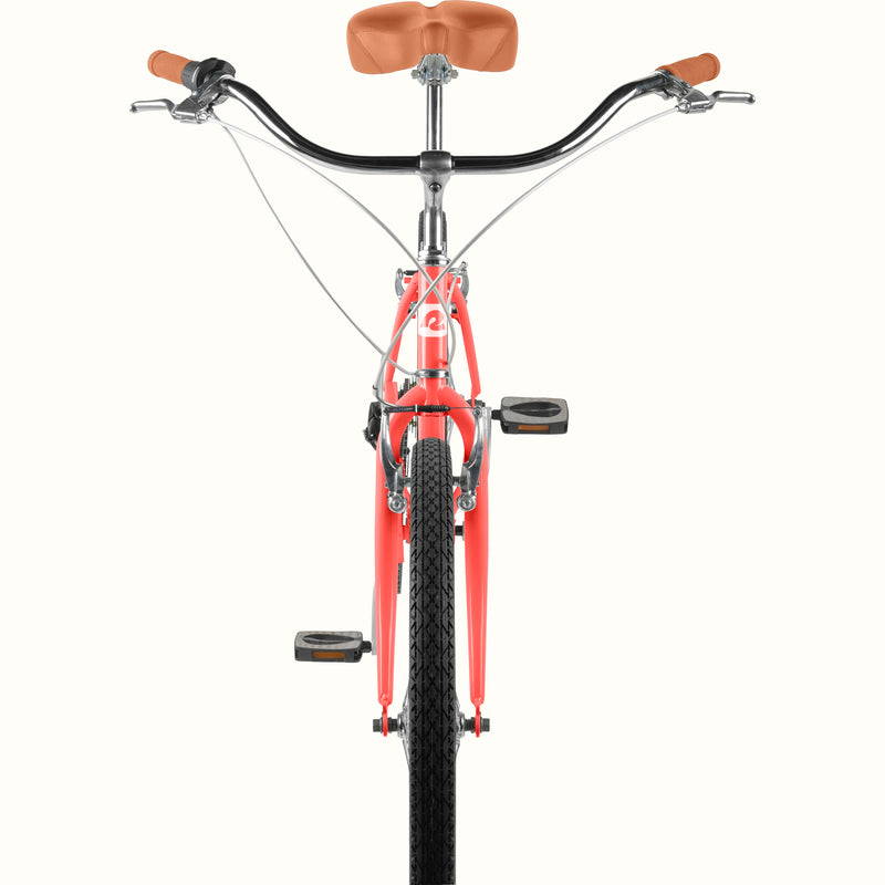 Close-up of the retrospec Chatham women's comfort bike handlebars, brake levers, and tan saddle.