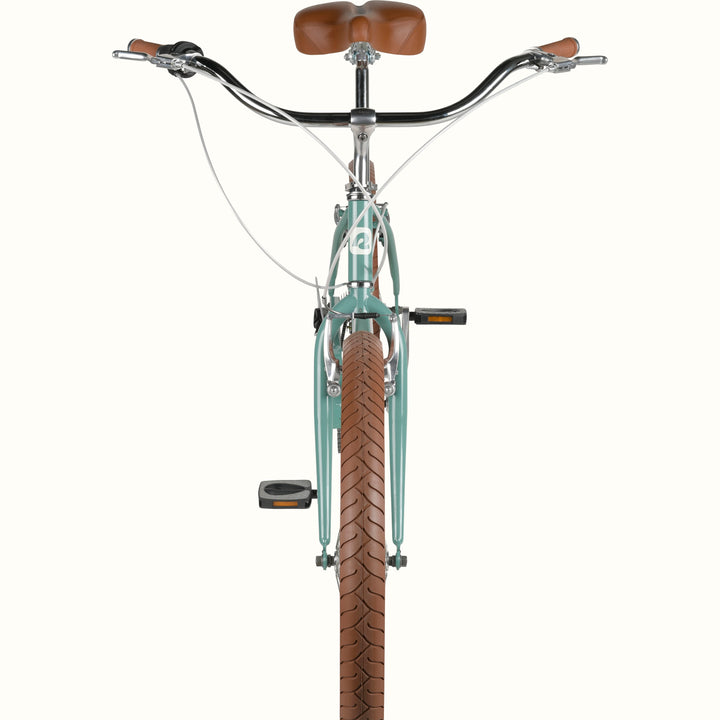 Front view of a vintage-style mint green bicycle with a brown seat and matching grips on an isolated background.