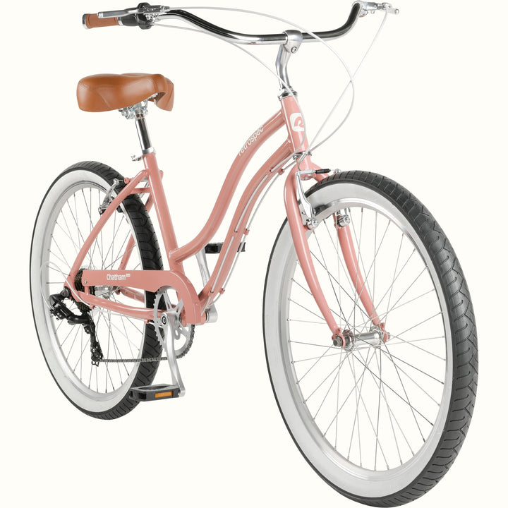 A pink cruiser bicycle with a brown saddle and white-wall tires on a white background.