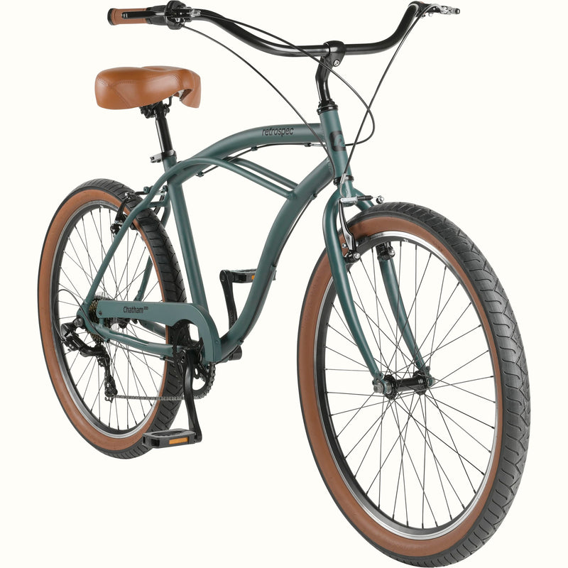 A vintage-style green beach cruiser bicycle with a brown saddle and grips.