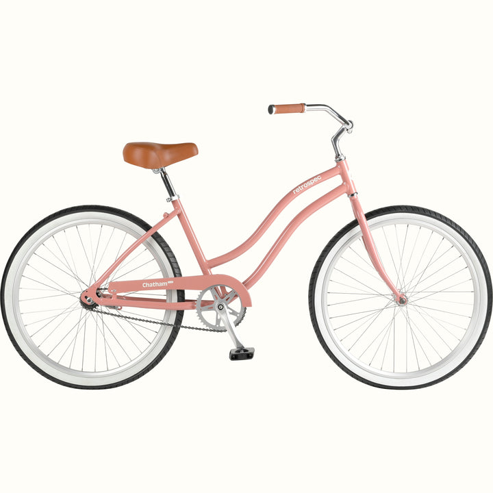 A pink cruiser bicycle with a brown saddle and white-walled tires, isolated on a white background.