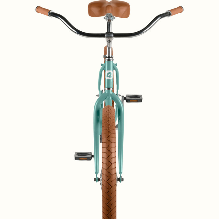 Front-facing detail of retrospec Chatham Plus cruiser bicycle in aquastone showing wide beach handlebars, brown grips, and tan tread tire.