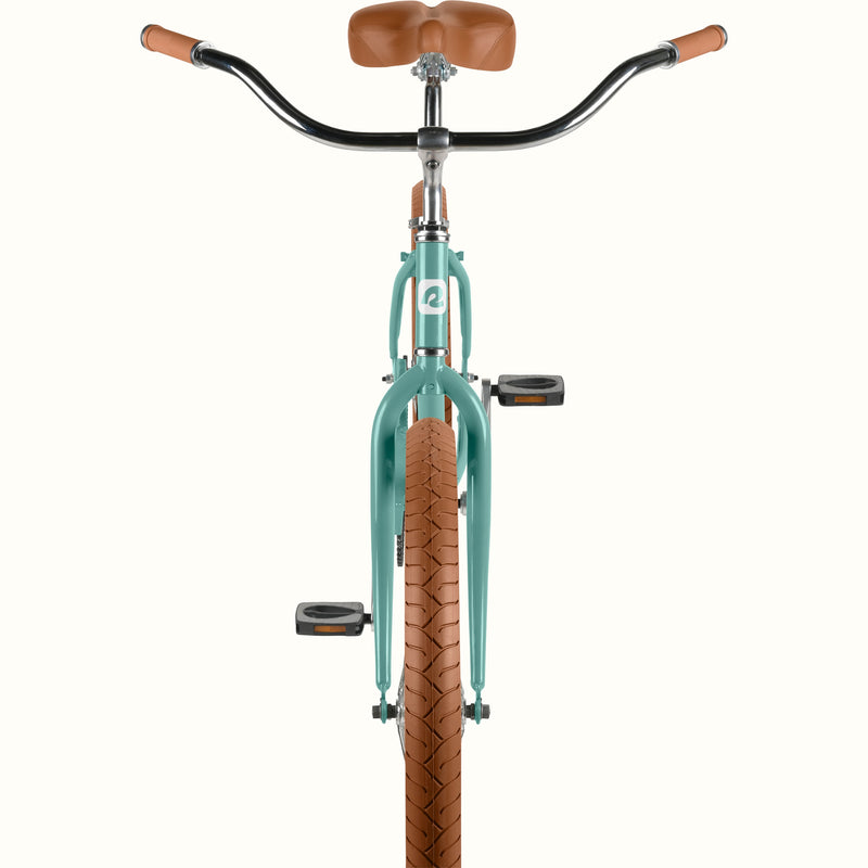 Front-facing detail of retrospec Chatham Plus cruiser bicycle in aquastone showing wide beach handlebars, brown grips, and tan tread tire.