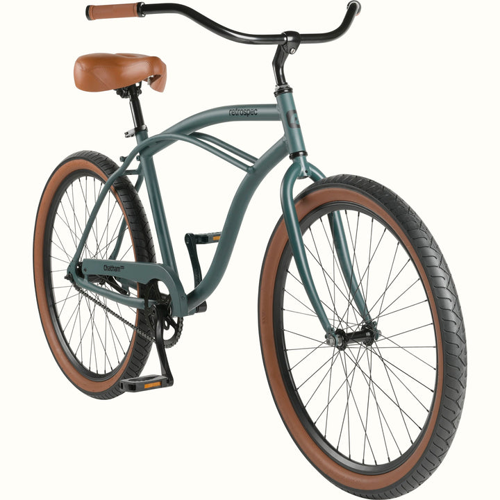 A green cruiser bicycle with brown saddle and grips, and black handlebars on a white background.