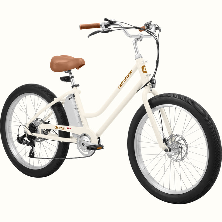 An eggshell Chatham Rev 3 Beach Cruiser Electric Bike - Step Through with a brown seat, wide tires, and a sleek design, ideal for casual riding.
