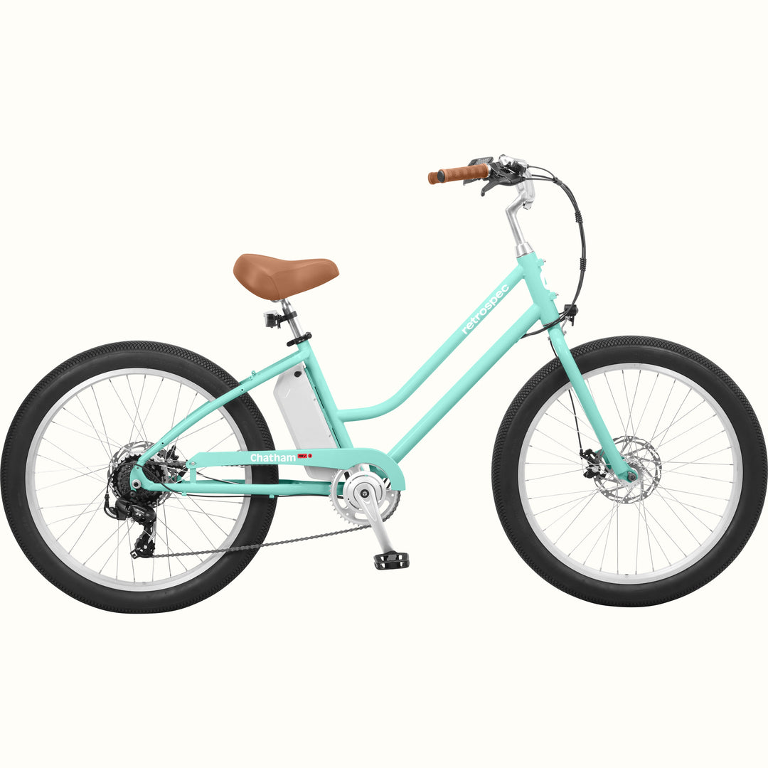 A seafoam Chatham Rev 3 Beach Cruiser Electric Bike - Step Through with a brown seat, wide tires, and a sleek design, ideal for casual riding.