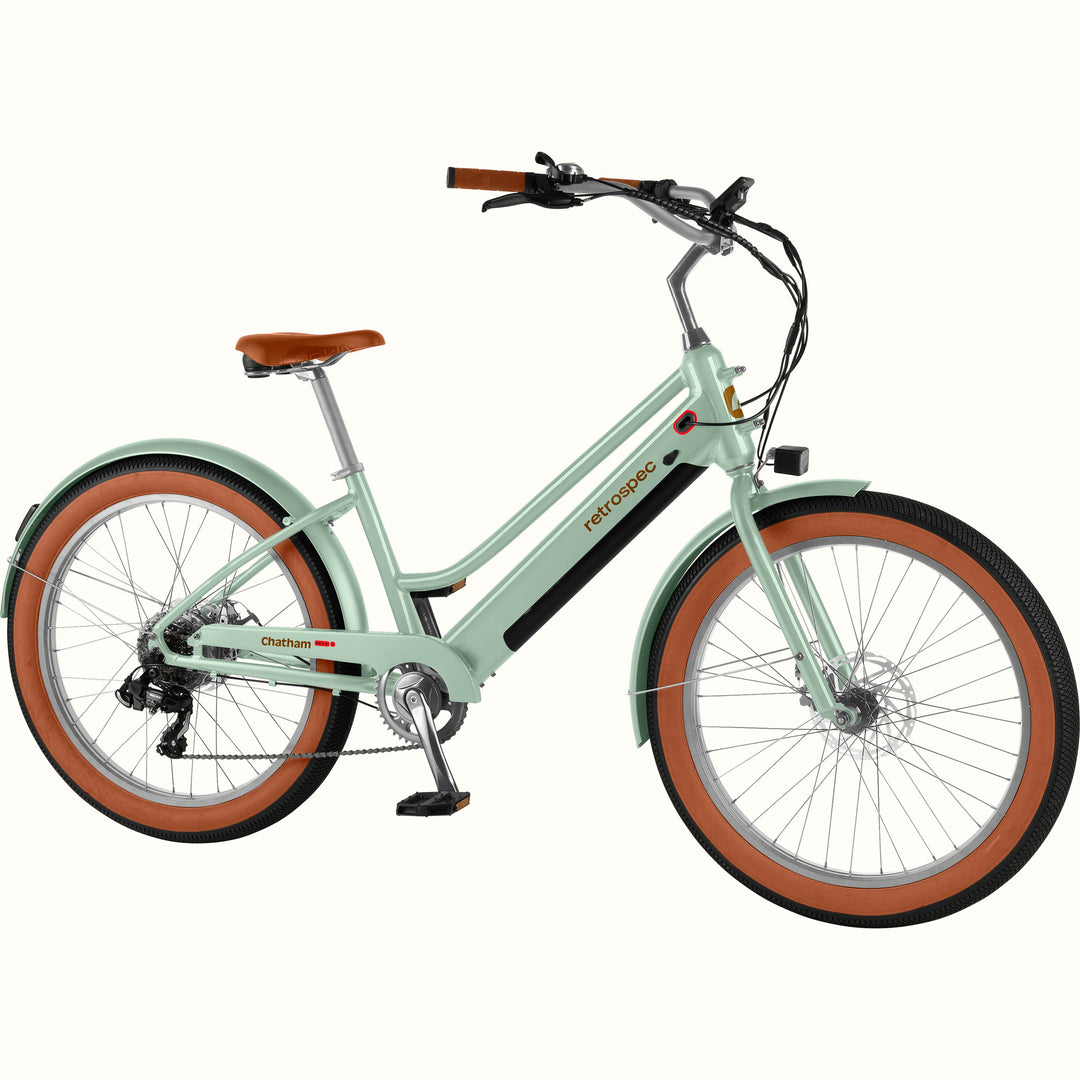 Light green Chatham Rev+ 2 Beach Cruiser Electric Bike - Step Through with brown wheels on a white background.