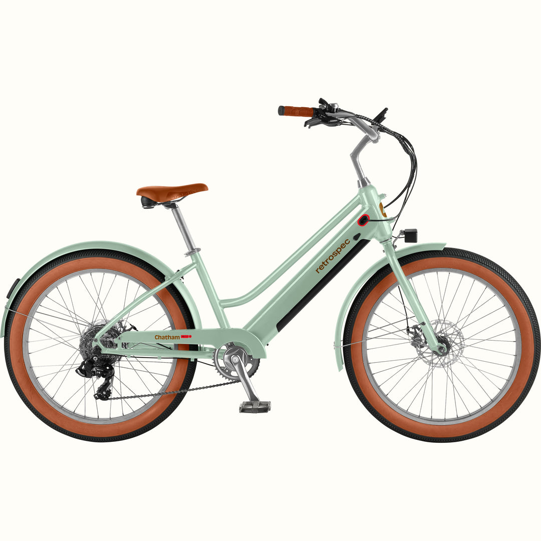 Light green Chatham Rev+ 2 Beach Cruiser Electric Bike - Step Through with brown wheels on a white background.
