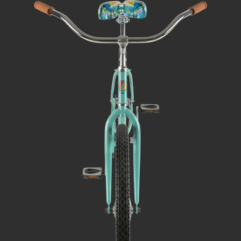 A front view of the mint green Grateful Dead Chatham Beach Cruiser Single Speed Step Through Bike with a floral tie-dye print on the seat, iconic Grateful Dead Steal Your Face or SYF graphic on the stem, and brown hand grips, displayed against a dark background.