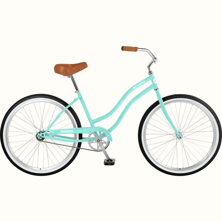 A seafoam step-through beach bicycle with a brown saddle and brown handlebar grips, shown from a side profile on a solid off-white background.