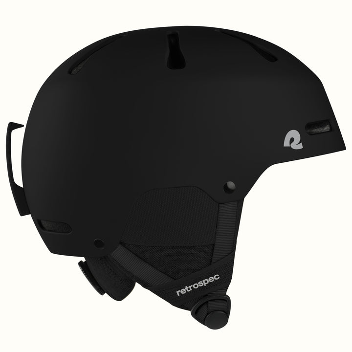 A matte black retrospec ski helmet shown from a side profile view against a clean off-white background.