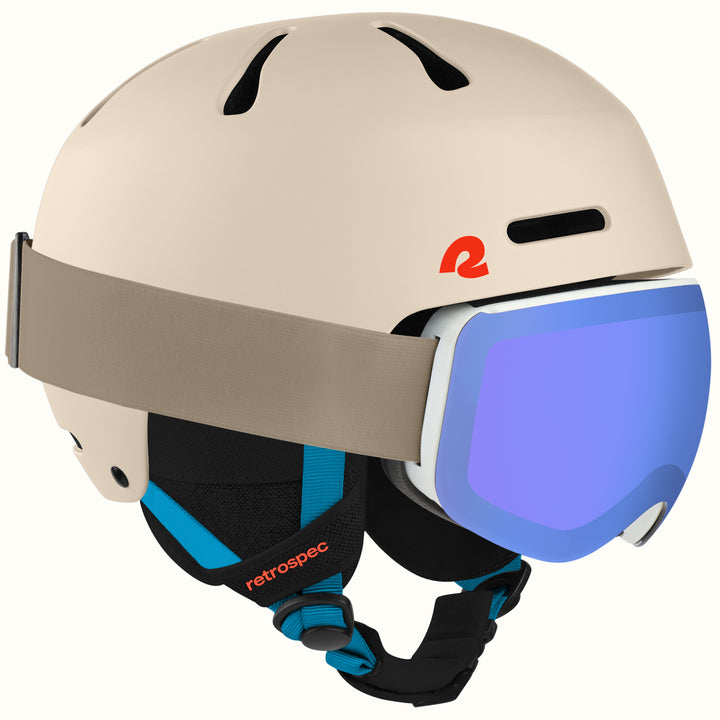 A beige ski helmet with a gray strap and a blue mirrored ski goggle, featuring a red retro logo on the side and black and blue chin strap details. The brand name 'retrospec' is visible on the strap.
