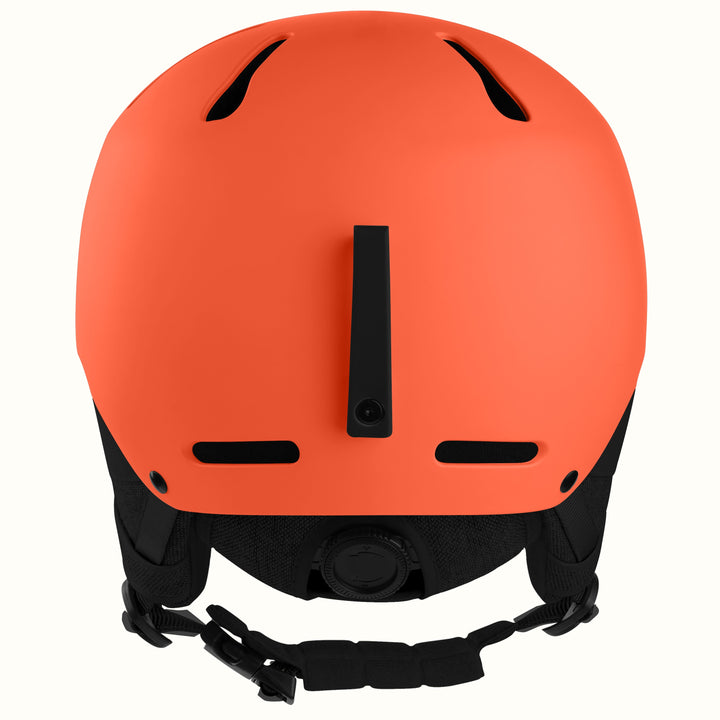 Matte orange ski helmet shown from the back, featuring black ventilation slots, a central vertical vent, and a black adjustable chin strap against a plain white background.
