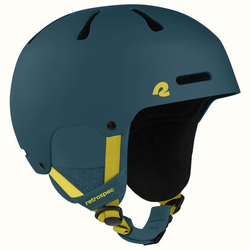 A matte dark teal ski helmet with yellow accents, including a yellow logo on the side and yellow adjustable chin straps, shown against a plain white background.