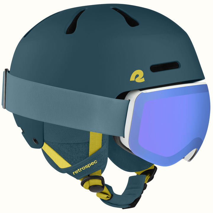A matte dark teal ski helmet with a matching strap and a white-framed ski goggle featuring a blue-purple mirrored lens. The helmet has yellow accents, including a stylized 'r' logo and the 'retrospec' brand name on the chin strap.