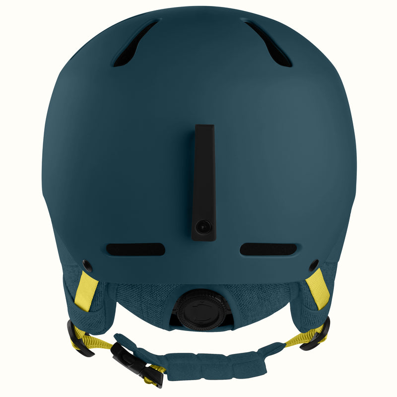 A matte dark teal ski helmet shown from the back, featuring black ventilation slots, a central vertical vent, and adjustable yellow and black chin straps, set against a plain white background.