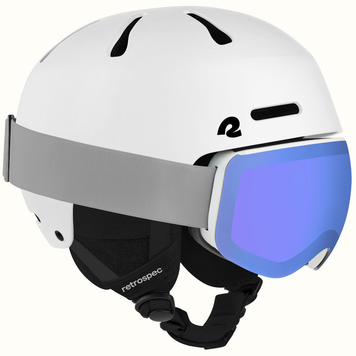 A white retrospec ski helmet with a gray strap and a blue mirrored ski goggle lens, shown on a clean off-white background.