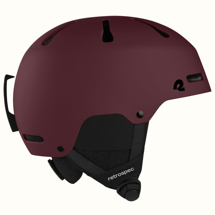 retrospec Comstock ski helmet in matte dark burgundy, side view showing adjustable dial and top vents.