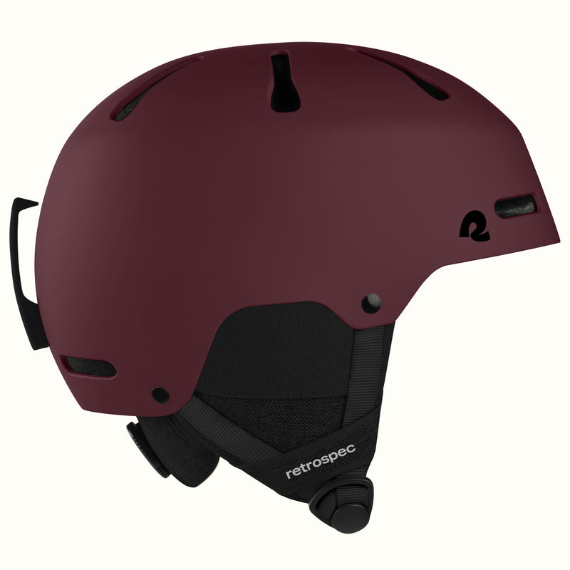 retrospec Comstock ski helmet in matte dark burgundy, side view showing adjustable dial and top vents.